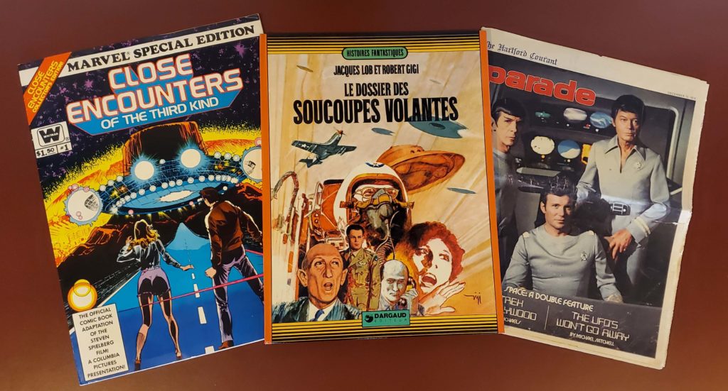 Images of a book and three magazines: "Close Encounters of the Third Kind," "Le Dossier Des Soucoupes Volantes," "Parade" with "Star Trek" characters.